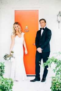 bride-and-groom-standing-by-orange-door